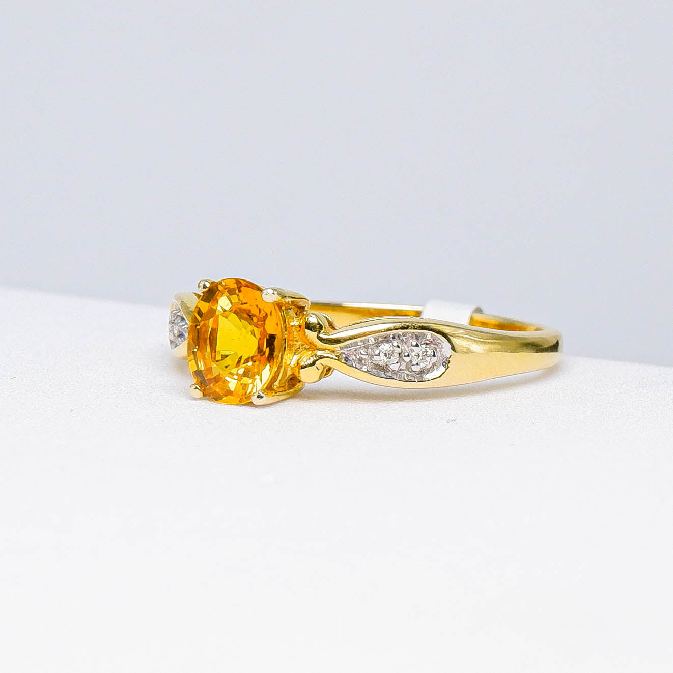 Yellow sapphire and diamond gold ring with marquise accents on a light background