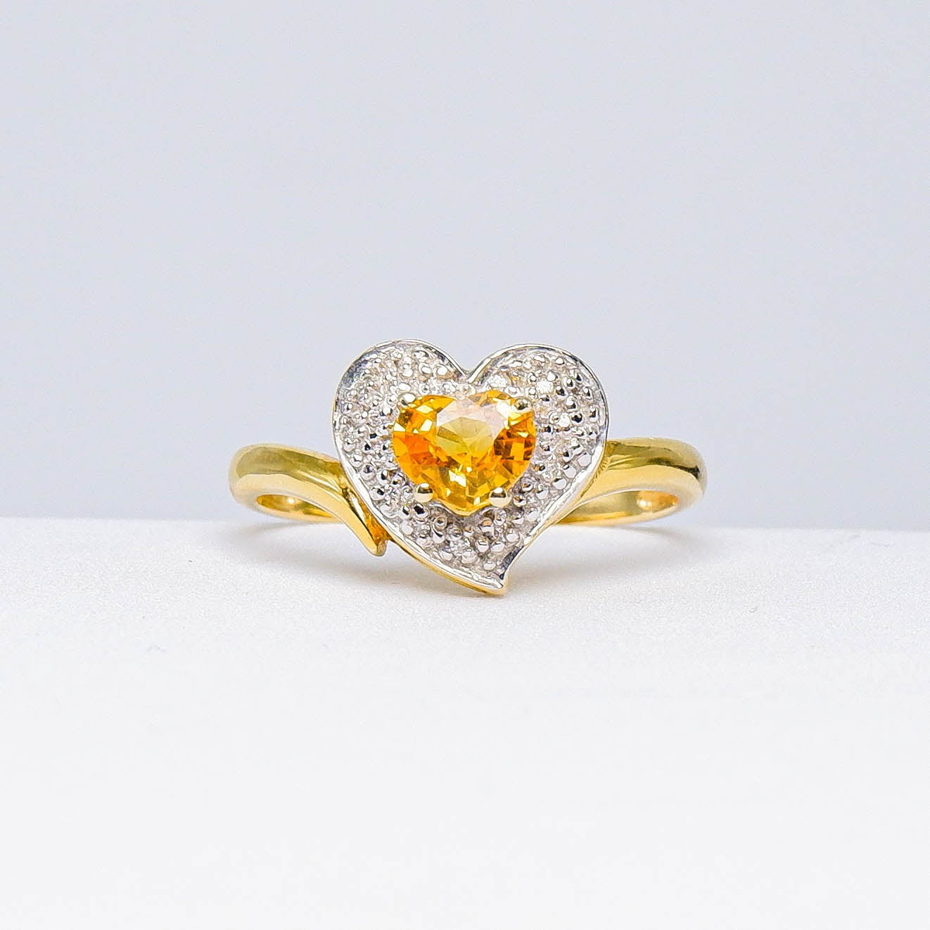 Heart-shaped gold ring with yellow gemstone center and white pavé accents